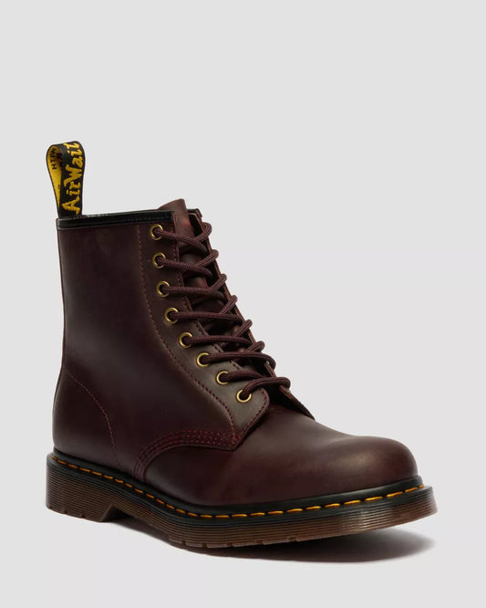 Brown leather boot with yellow stitching on a light gray background