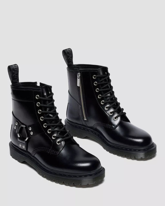 Pair of black leather boots with zippers on a light gray background