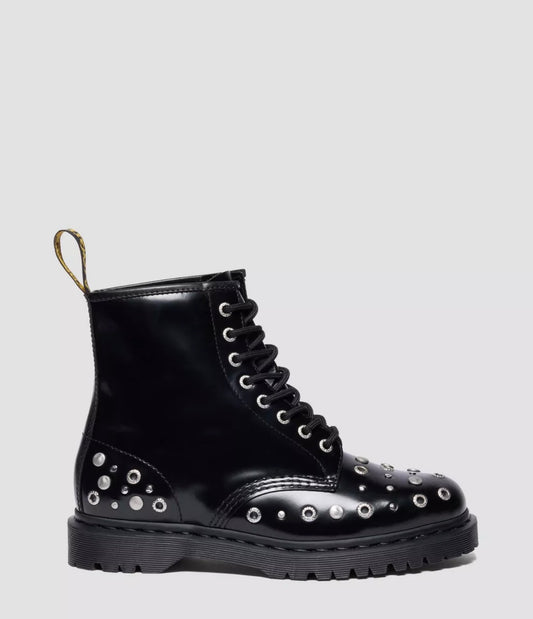 Black leather boot with studs on a light gray background