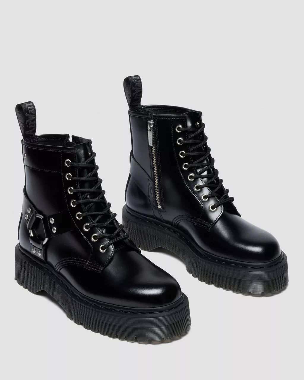Pair of black leather boots with zippers on a light gray background