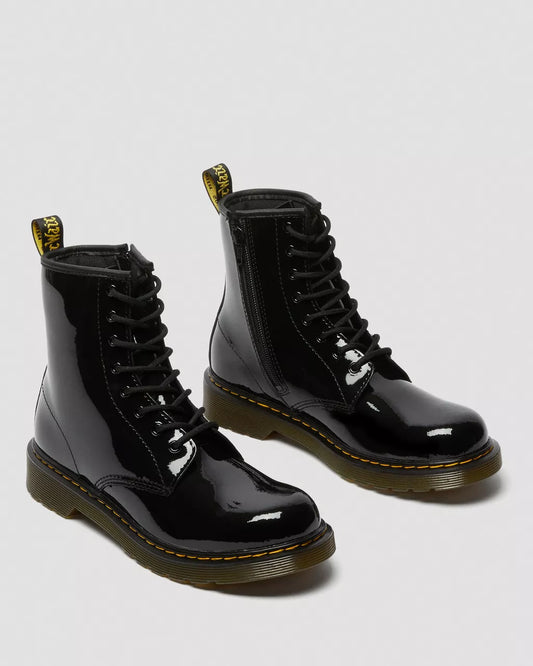 A pair of black patent leather lace-up boots with yellow stitching and a heel loop.