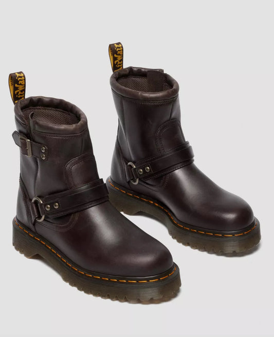 Pair of brown leather boots with buckles on a light gray background