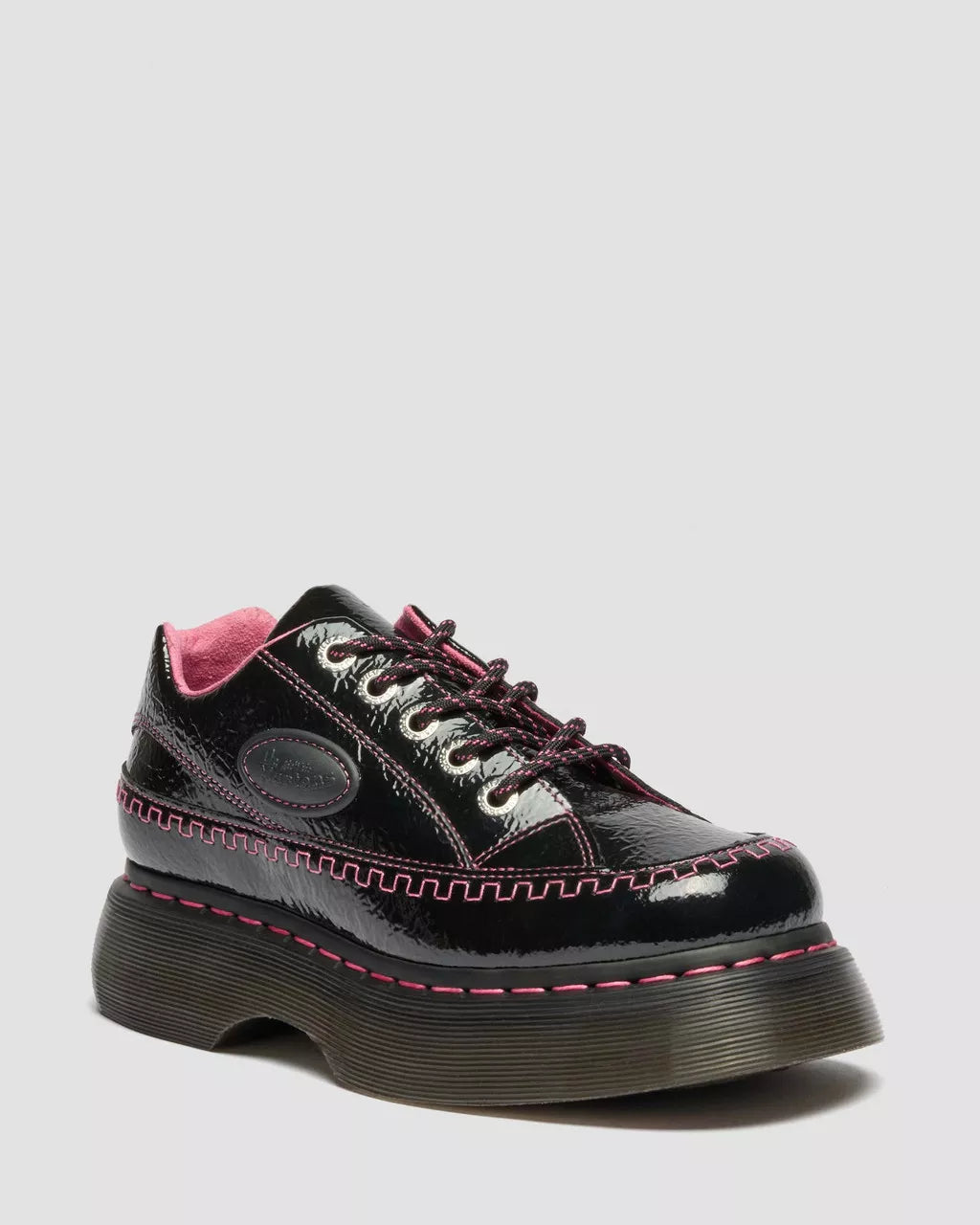 Black shiny shoe with pink accents on a light gray background