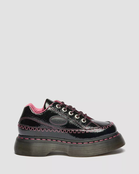 Black shiny shoe with pink accents on a light gray background