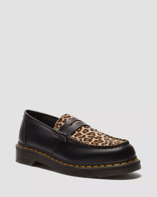 Black loafer with leopard print pattern on a light gray background
