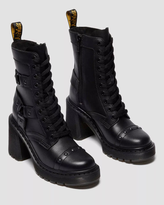 Black leather boots with high block heels on a light gray background