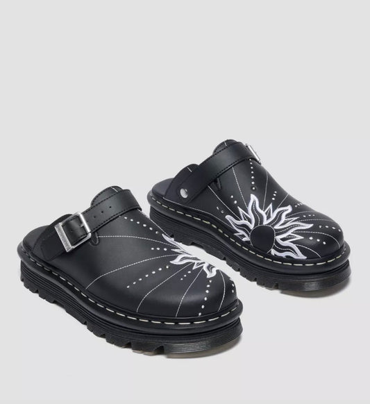 Black clogs with white designs on a light gray background