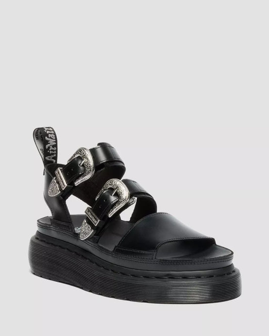 Black sandal with multiple straps on a light gray background