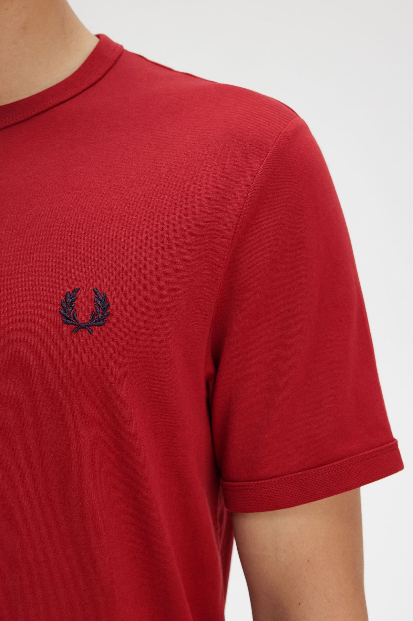 Red t-shirt with a small logo on a white background