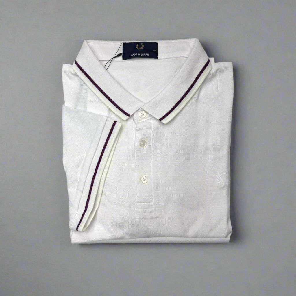 Folded white polo shirt with purple trim on a white background