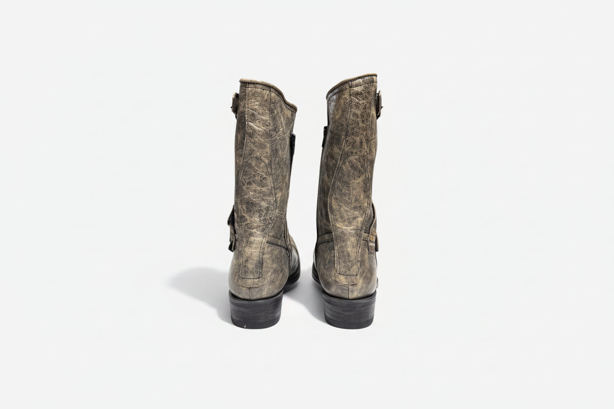 Pair of worn leather boots on a white background
