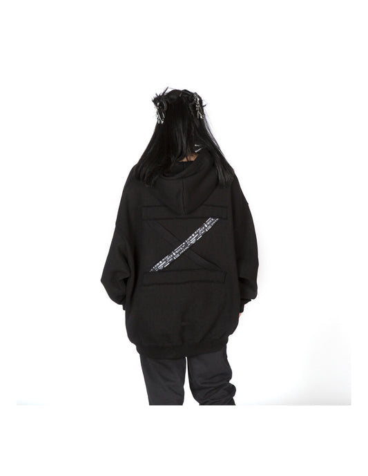 Person wearing a black hoodie with a white design on the back against a white background