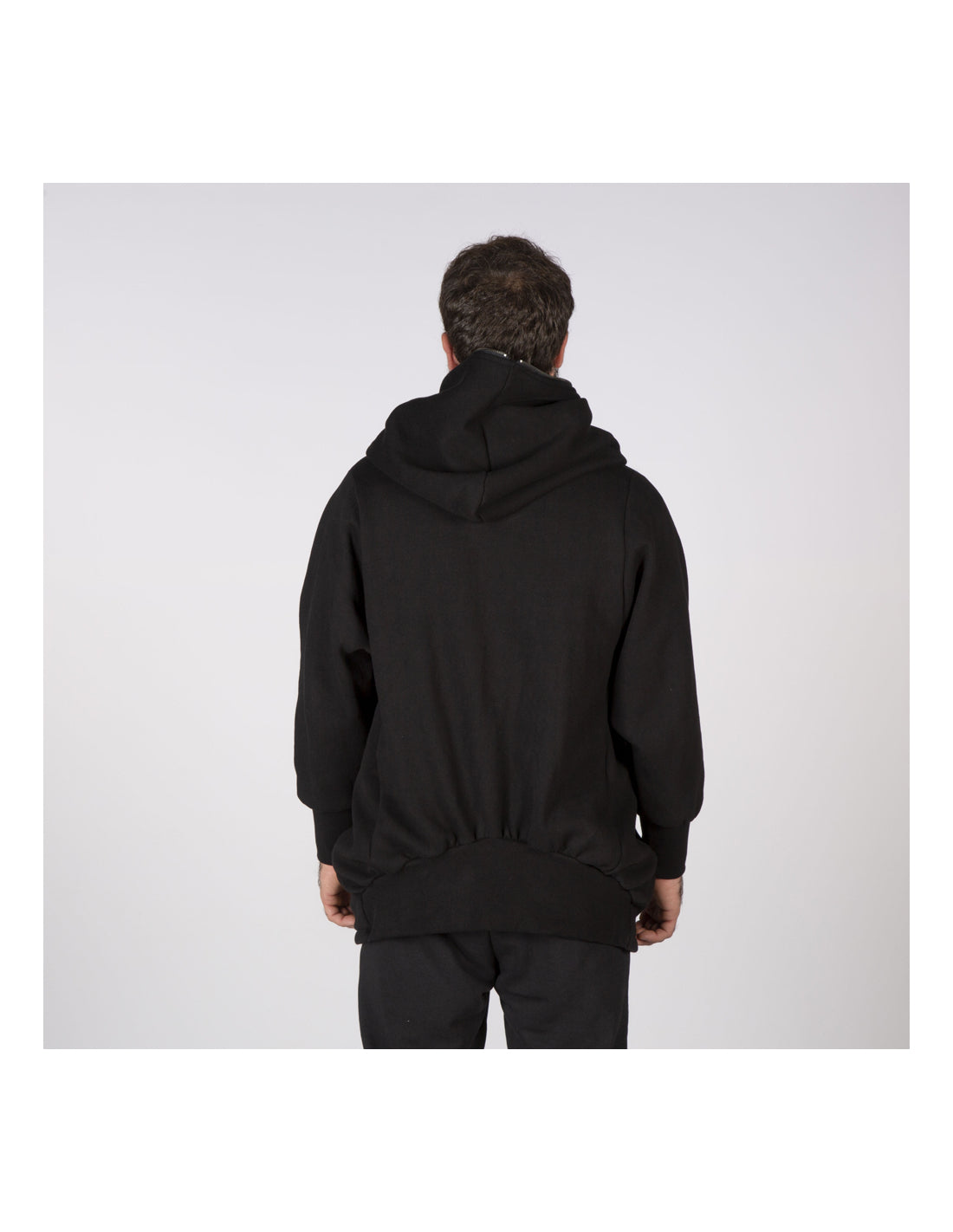 Person wearing a black hoodie on a light gray background