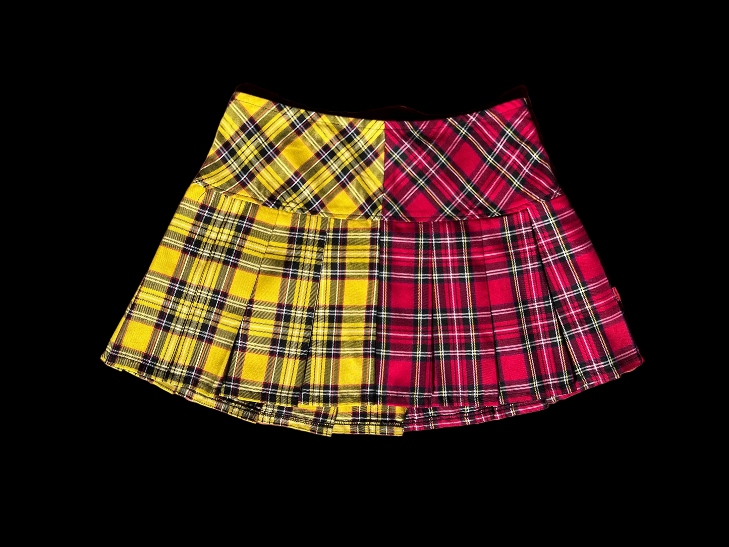 Plaid skirt with yellow and red pattern on a textured brown surface