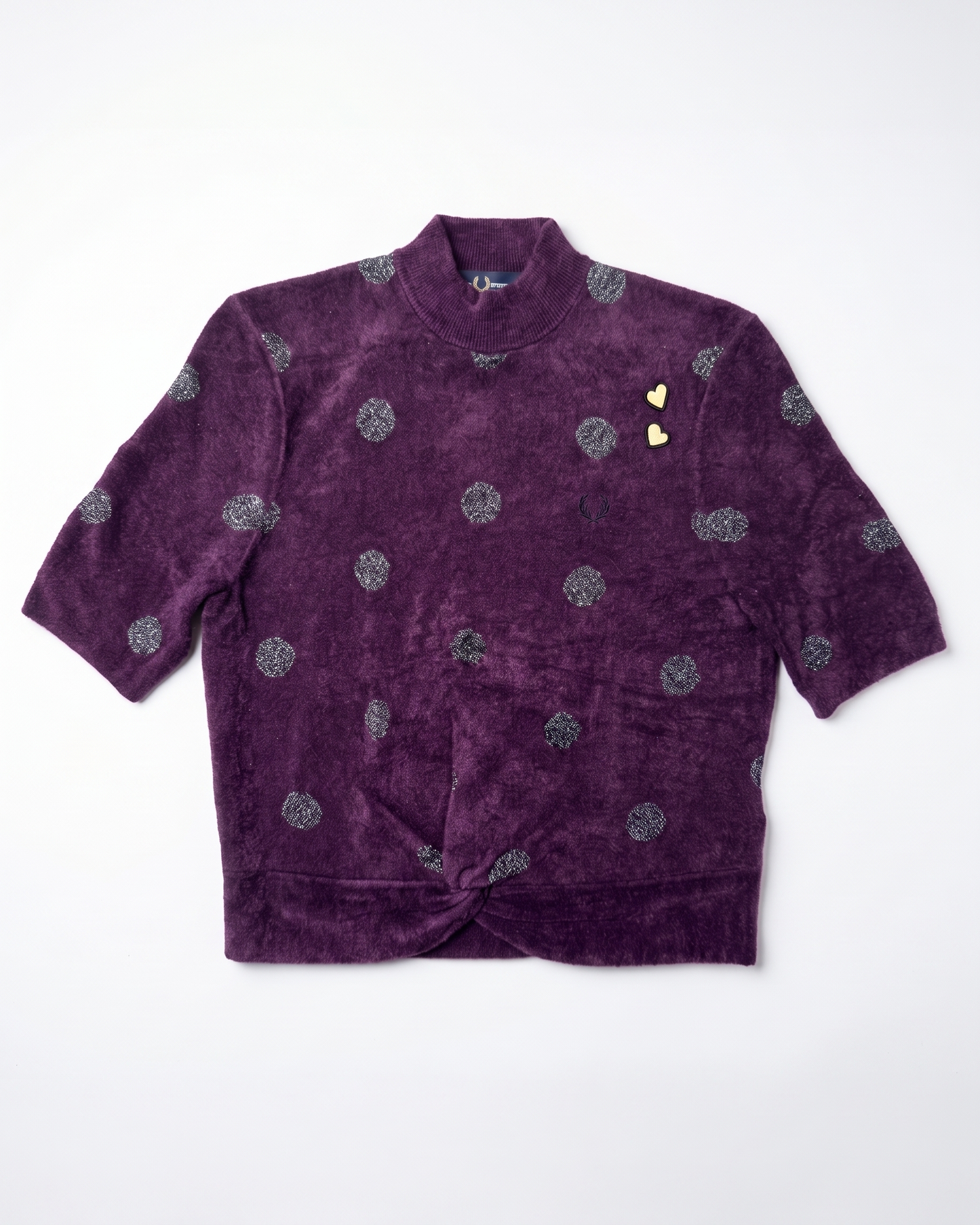A purple velvet short-sleeve jacket with a high collar, featuring a pattern of silver glittery circular motifs and two small gold heart-shaped embellishments on the chest, laid flat against a white background.