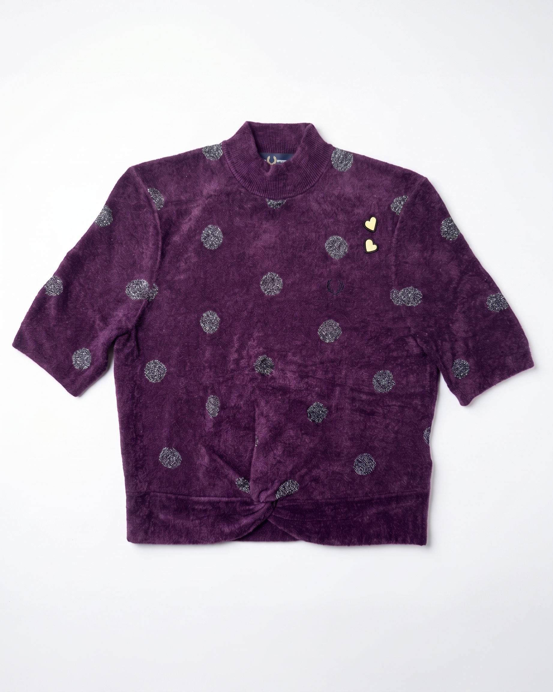 A purple velvet short-sleeve jacket with a high collar, featuring a pattern of silver glittery circular motifs and two small gold heart-shaped embellishments on the chest, laid flat against a white background.