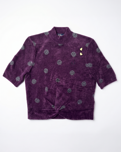 A purple velvet short-sleeve jacket with a high collar, featuring a pattern of silver glittery circular motifs and two small gold heart-shaped embellishments on the chest, laid flat against a white background.