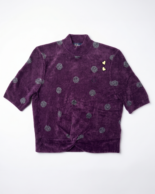 A purple velvet short-sleeve jacket with a high collar, featuring a pattern of silver glittery circular motifs and two small gold heart-shaped embellishments on the chest, laid flat against a white background.