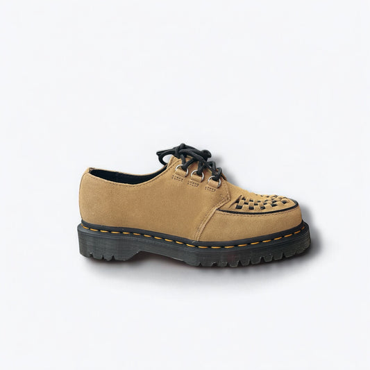 A single tan suede shoe with a black sole, featuring a lace-up closure and a perforated pattern on the upper.
