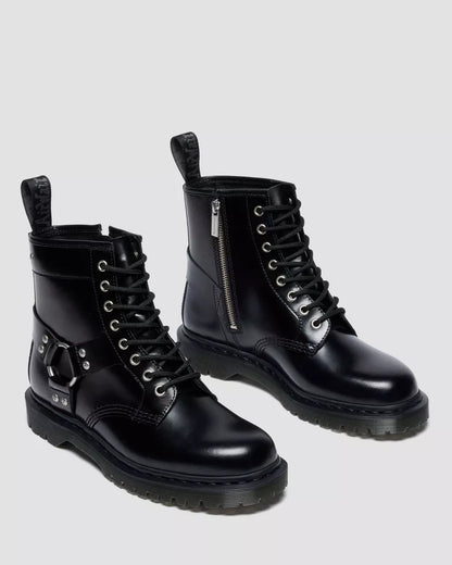 Pair of black leather boots with zippers on a light gray background