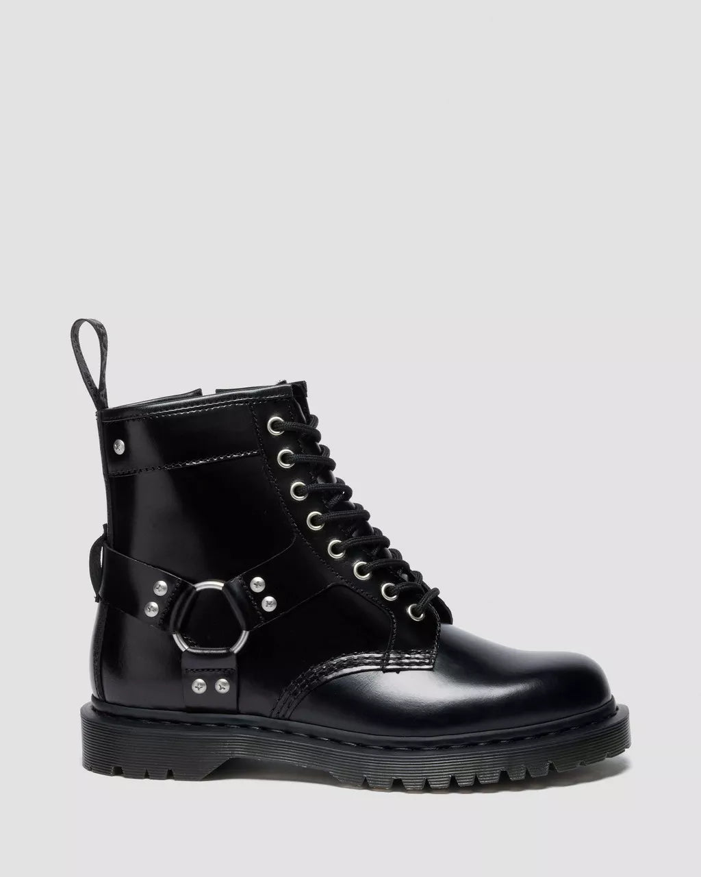 Black leather boot with buckles on a light gray background
