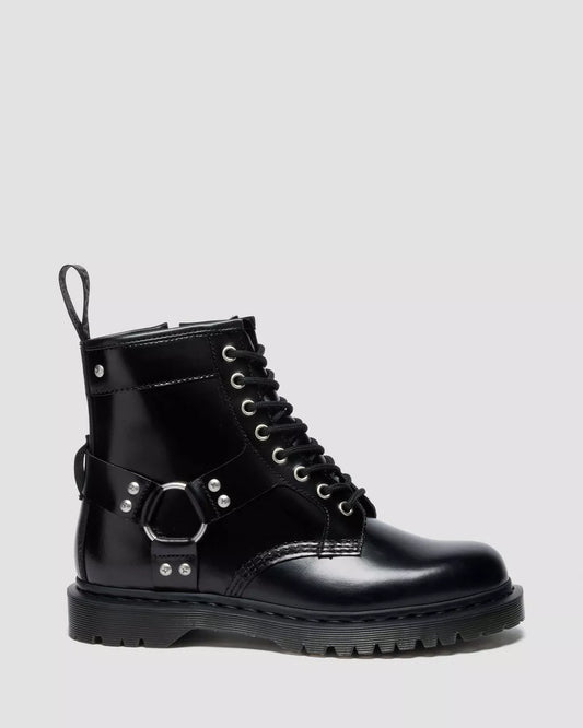 Black leather boot with buckles on a light gray background