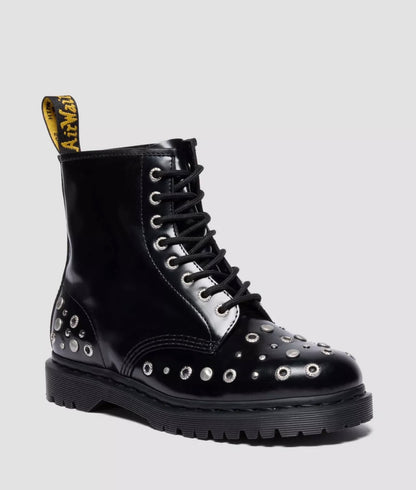 Black leather boot with studs and a white sole on a light gray background