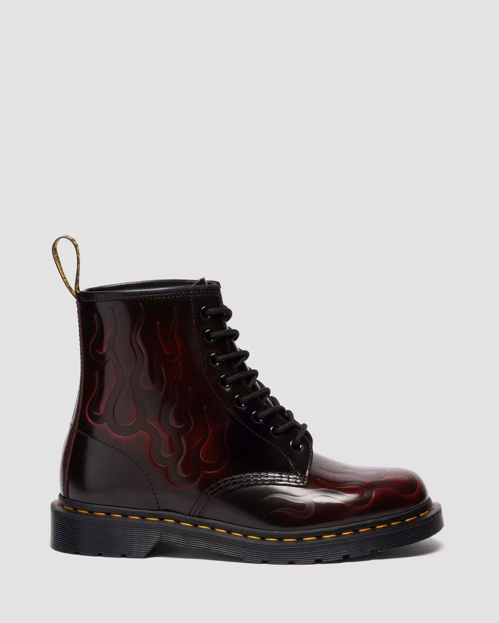 Black leather boot with red flame pattern on a light gray background