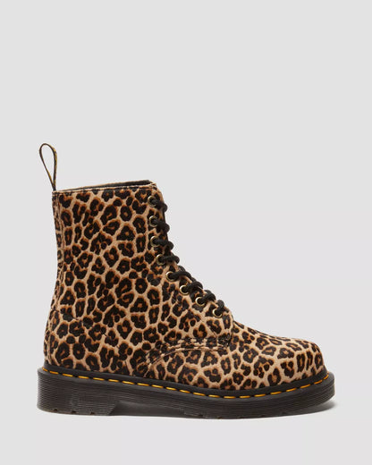 A pair of Dr. Martens 1460 leopard print boots with yellow stitching on a white background.