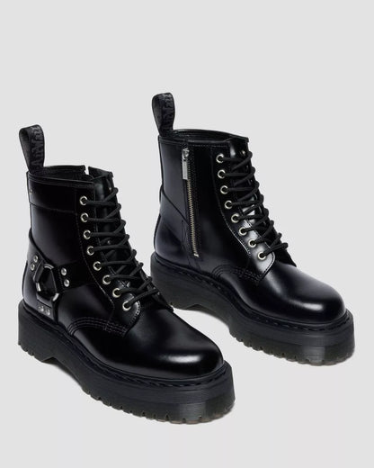 Pair of black leather boots with zippers on a light gray background