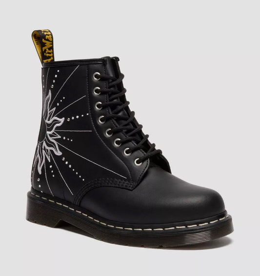 Black boot with white floral design on a light gray background