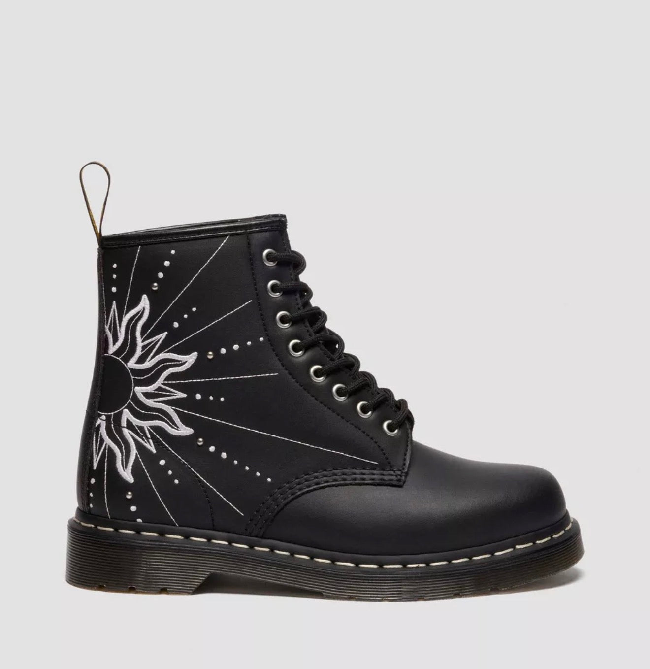 Black boot with white sun design on a light gray background
