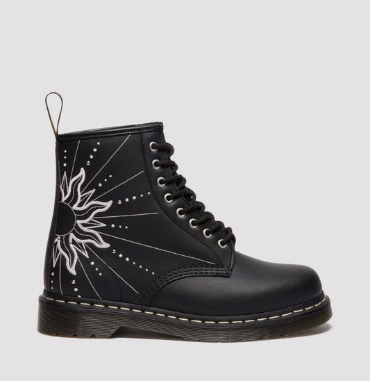 Black boot with white sun design on a light gray background
