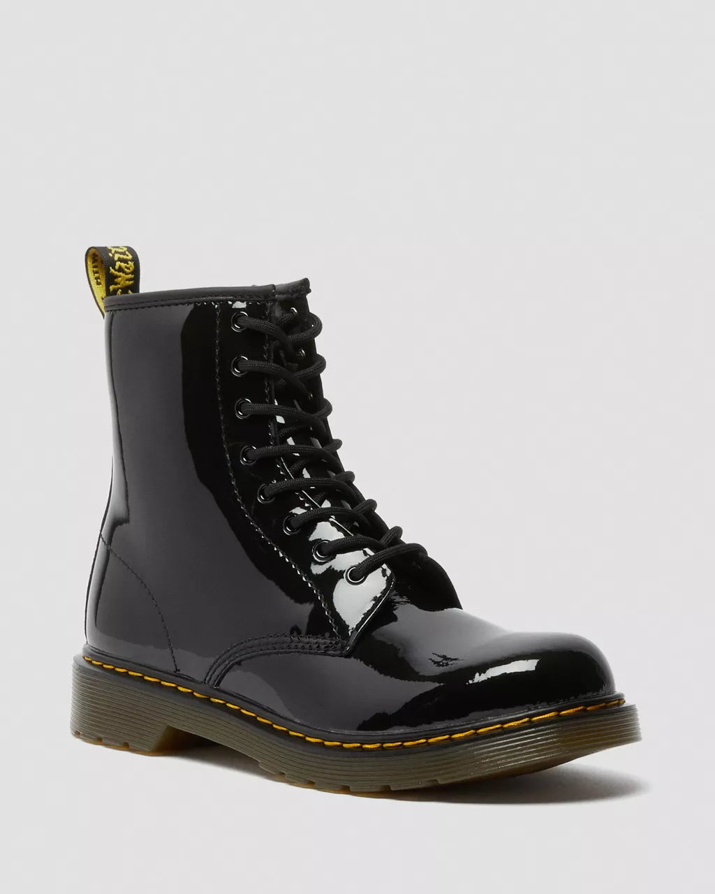 A youth patent leather lace-up boot with yellow stitching and a black and yellow heel loop.