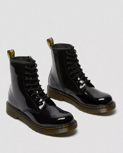 A pair of black patent leather lace-up boots with yellow stitching and a heel loop.