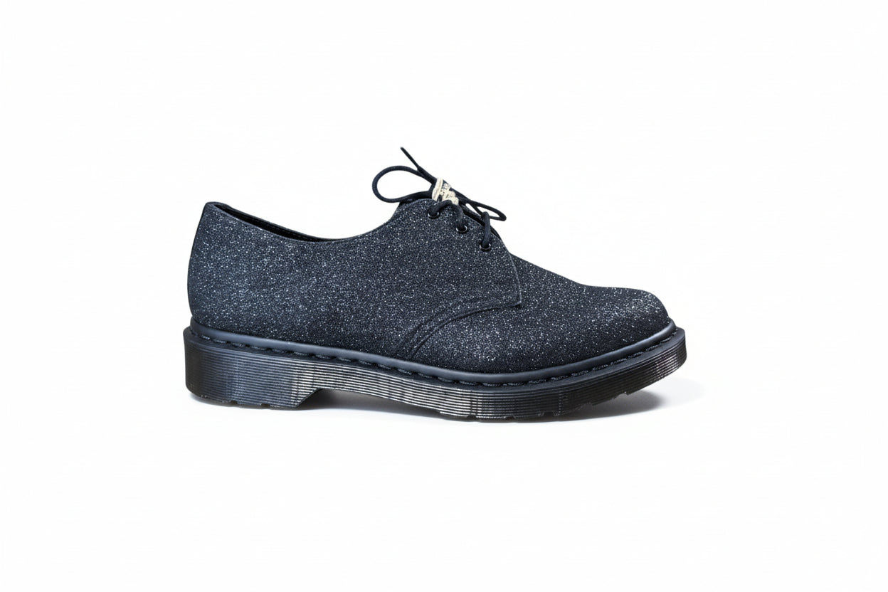 Blue glittery shoe with a black sole on a white background