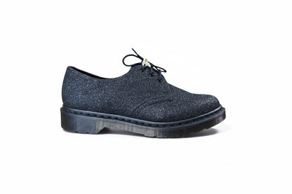 Blue glittery shoe with a black sole on a white background