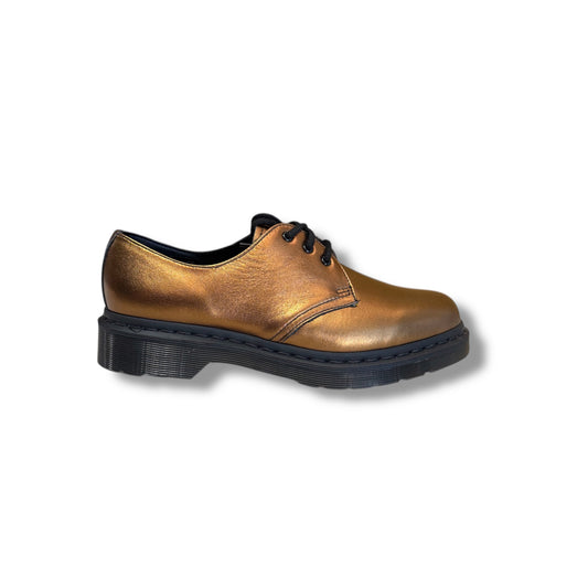 Bronze-colored leather shoe with black sole on a white background