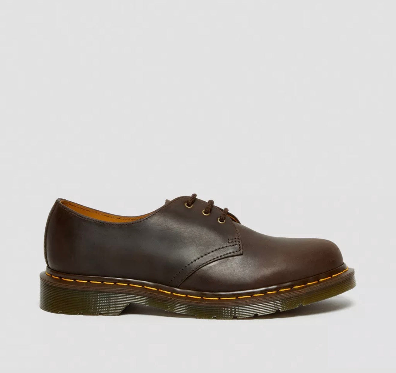Brown leather shoe on a light gray background