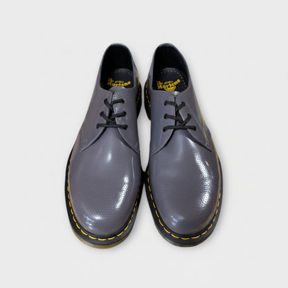 Pair of gray shoes with black soles on a white background