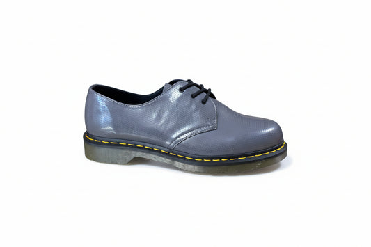 Shiny blue shoe with black sole on a light gray background
