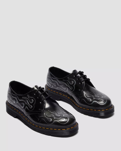 Black leather shoes with flame pattern on a light gray background
