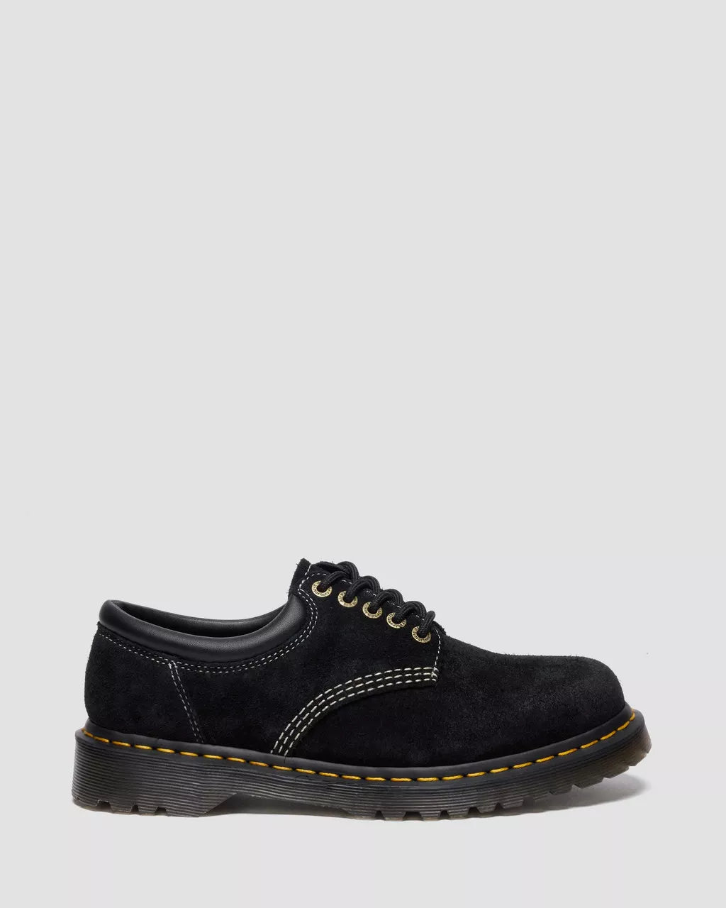 Black leather shoe with yellow stitching on a white background