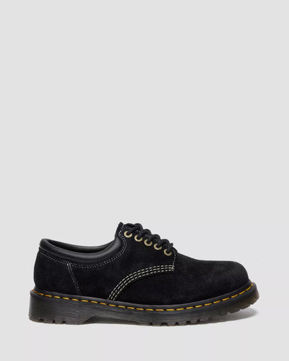 Black leather shoe with yellow stitching on a white background