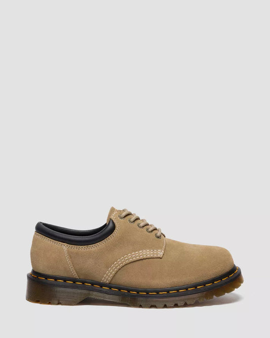 Beige leather shoe with black sole on a light gray background