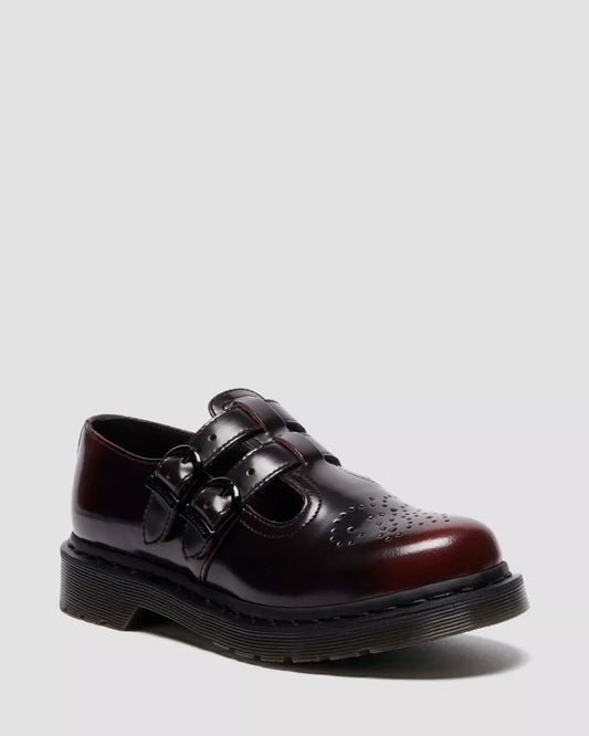 Brown leather shoe with black soles on a light gray background