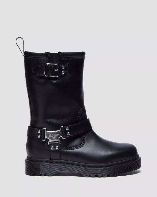 Black boot with metal buckles on a light gray background
