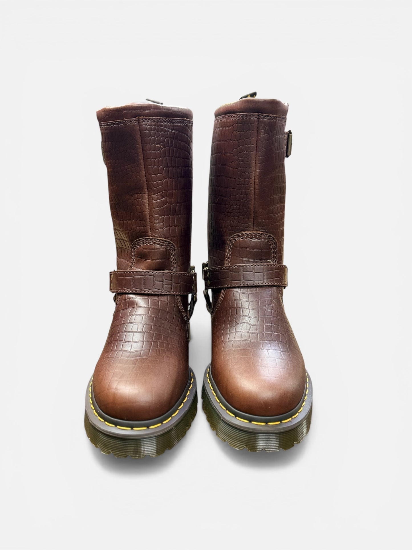 Pair of brown leather boots with buckle details on a white background