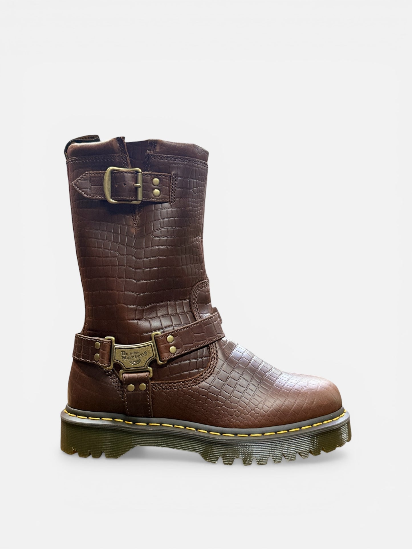 Brown leather boot with gold buckles on a white background