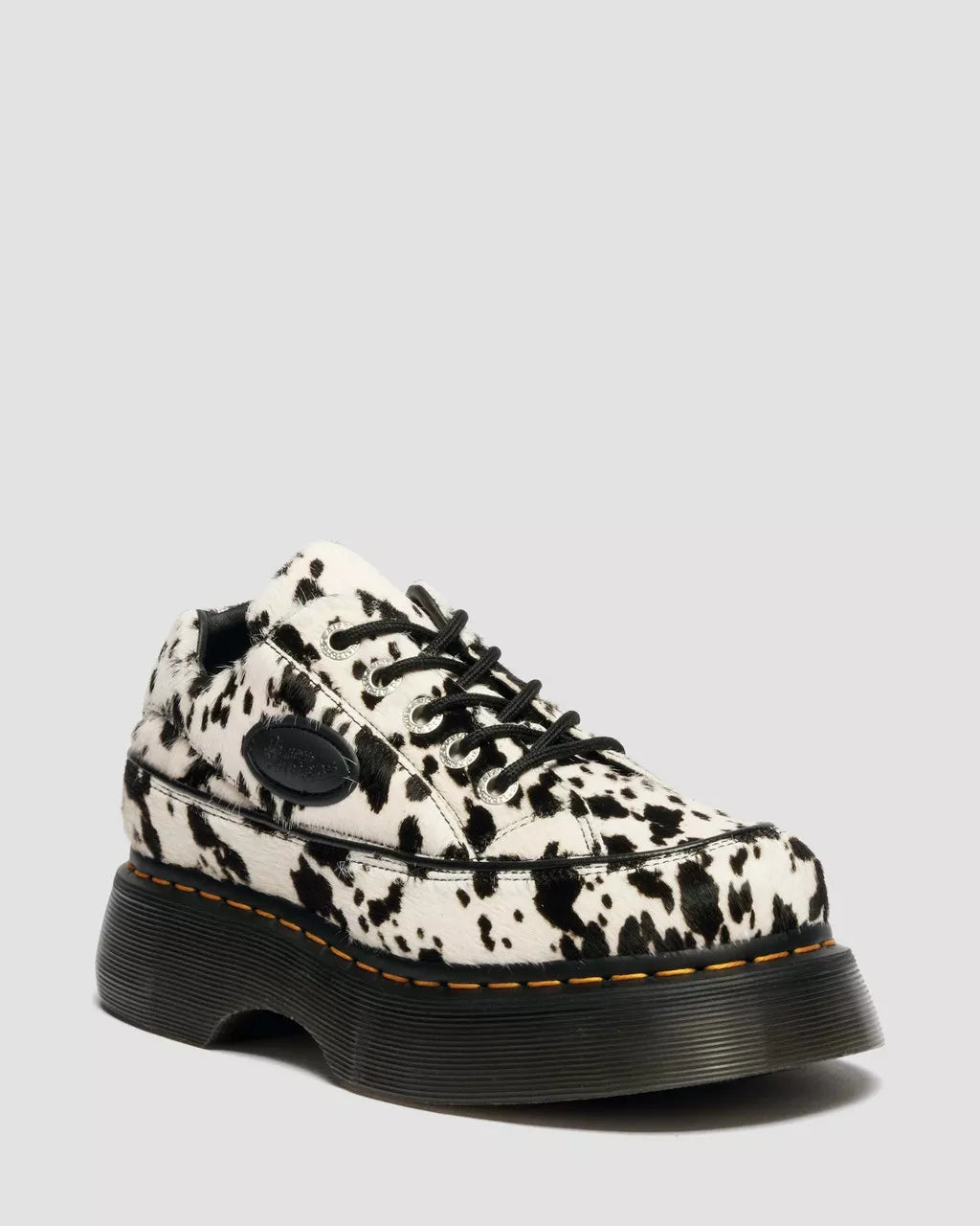 Black and white cow print shoe on a light gray background